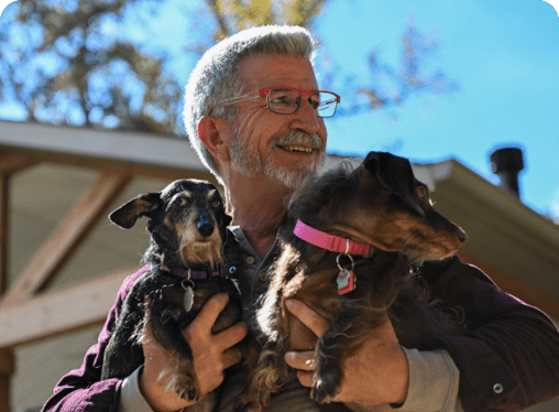 Theron holding 2 dogs.